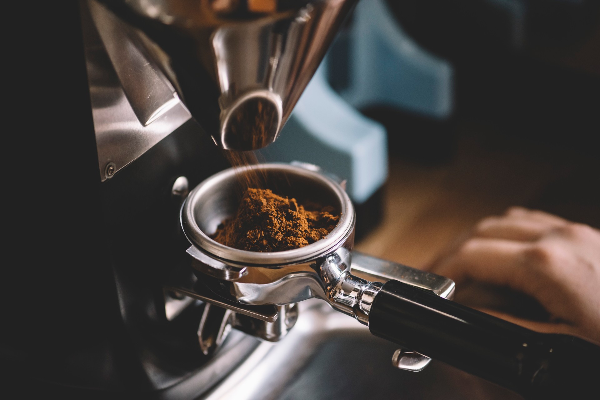 Coffee beans in a portafilter by the coffee grinder