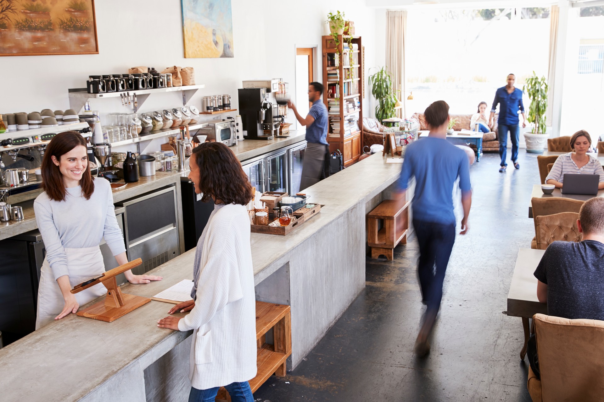 Customer at a counter of a busy coffee shop, elevated view